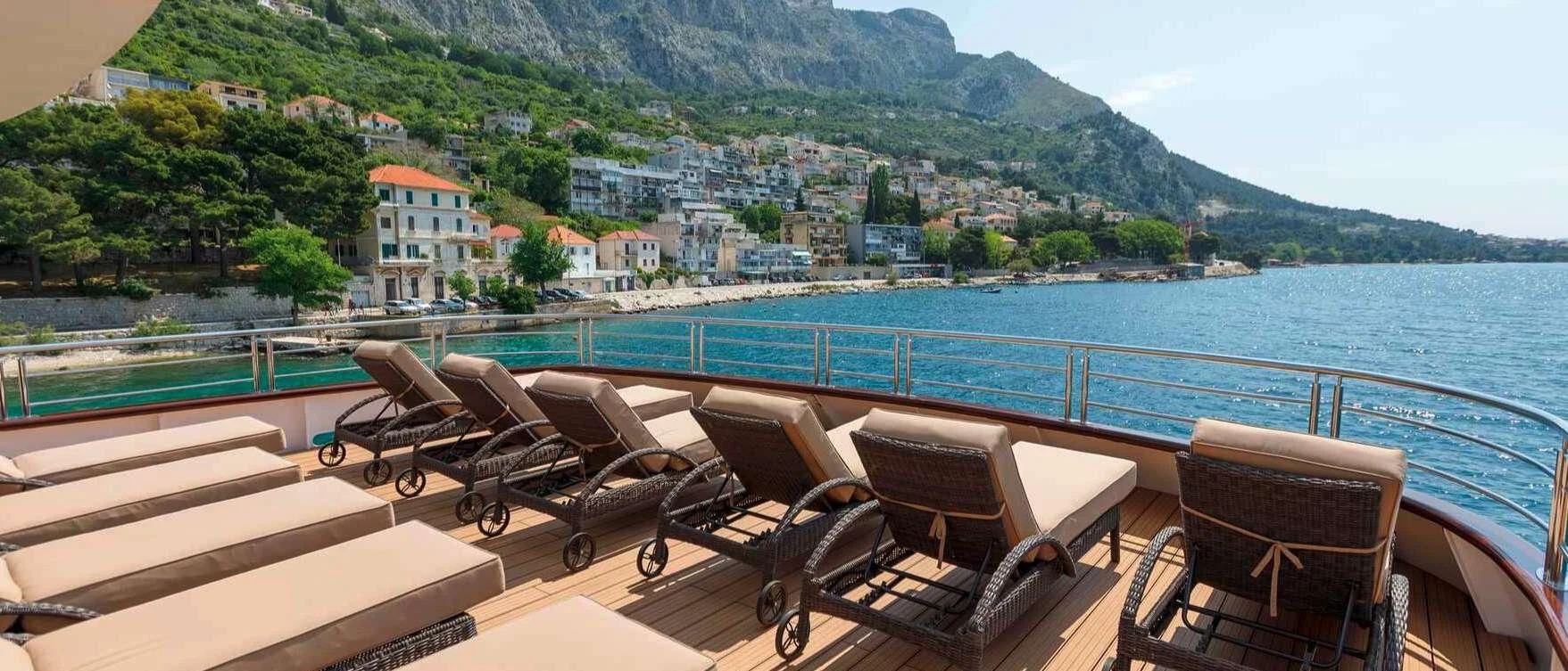 a group of chairs on a deck overlooking a body of water aboard QUEEN ELEGANZA Yacht for Sale