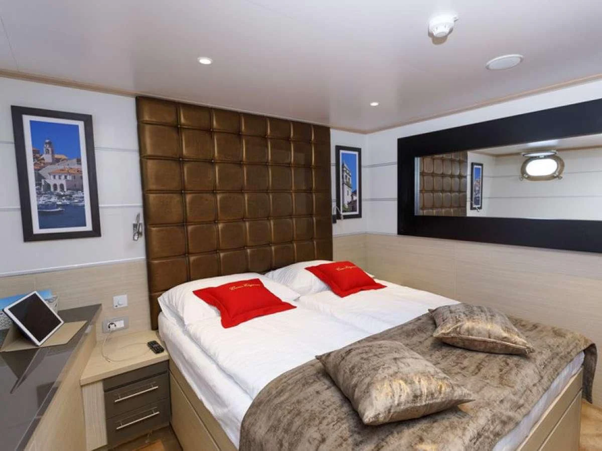 a bedroom with a bed and a television aboard QUEEN ELEGANZA Yacht for Sale