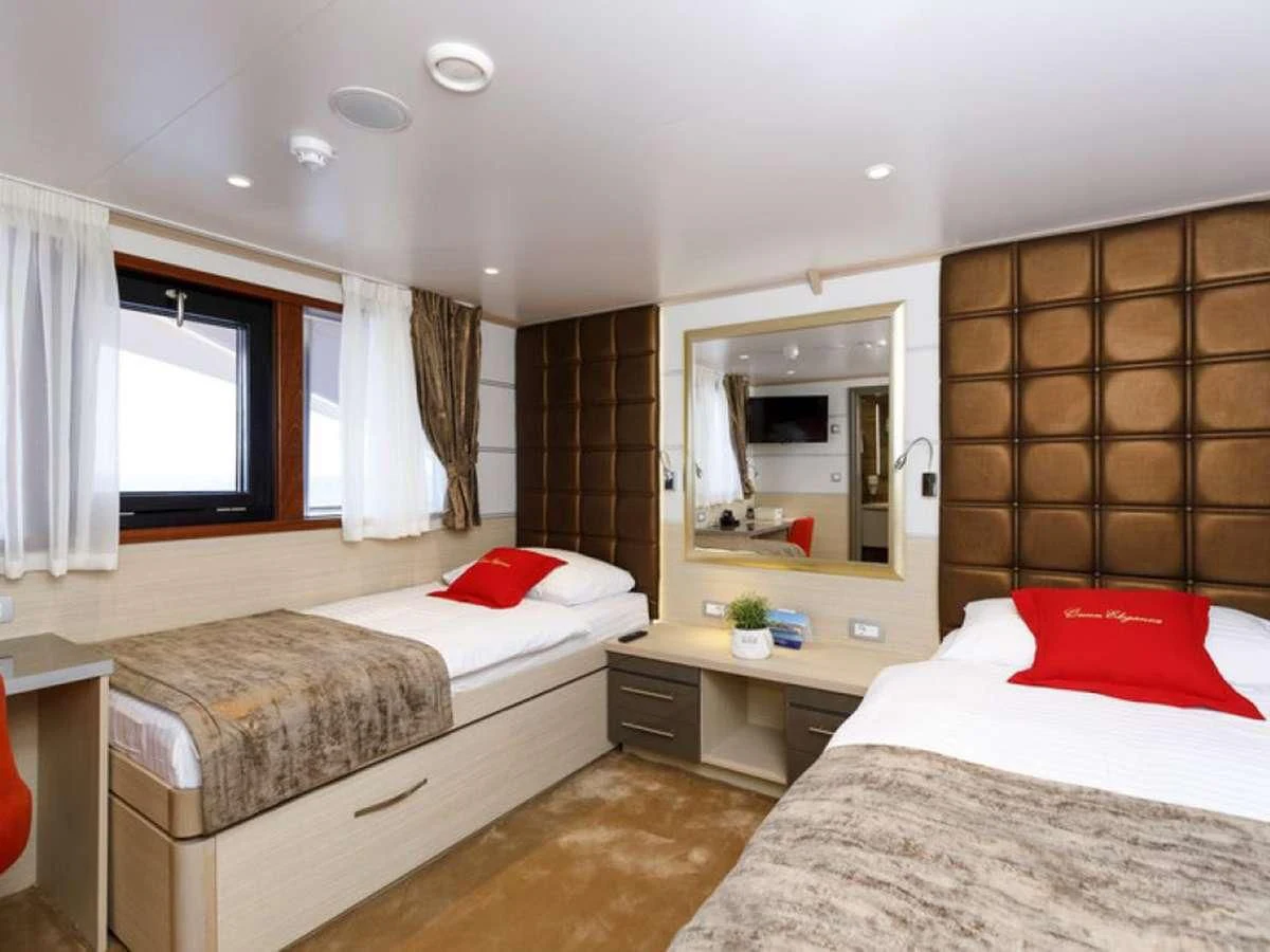 a couple of beds in a hotel room aboard QUEEN ELEGANZA Yacht for Sale