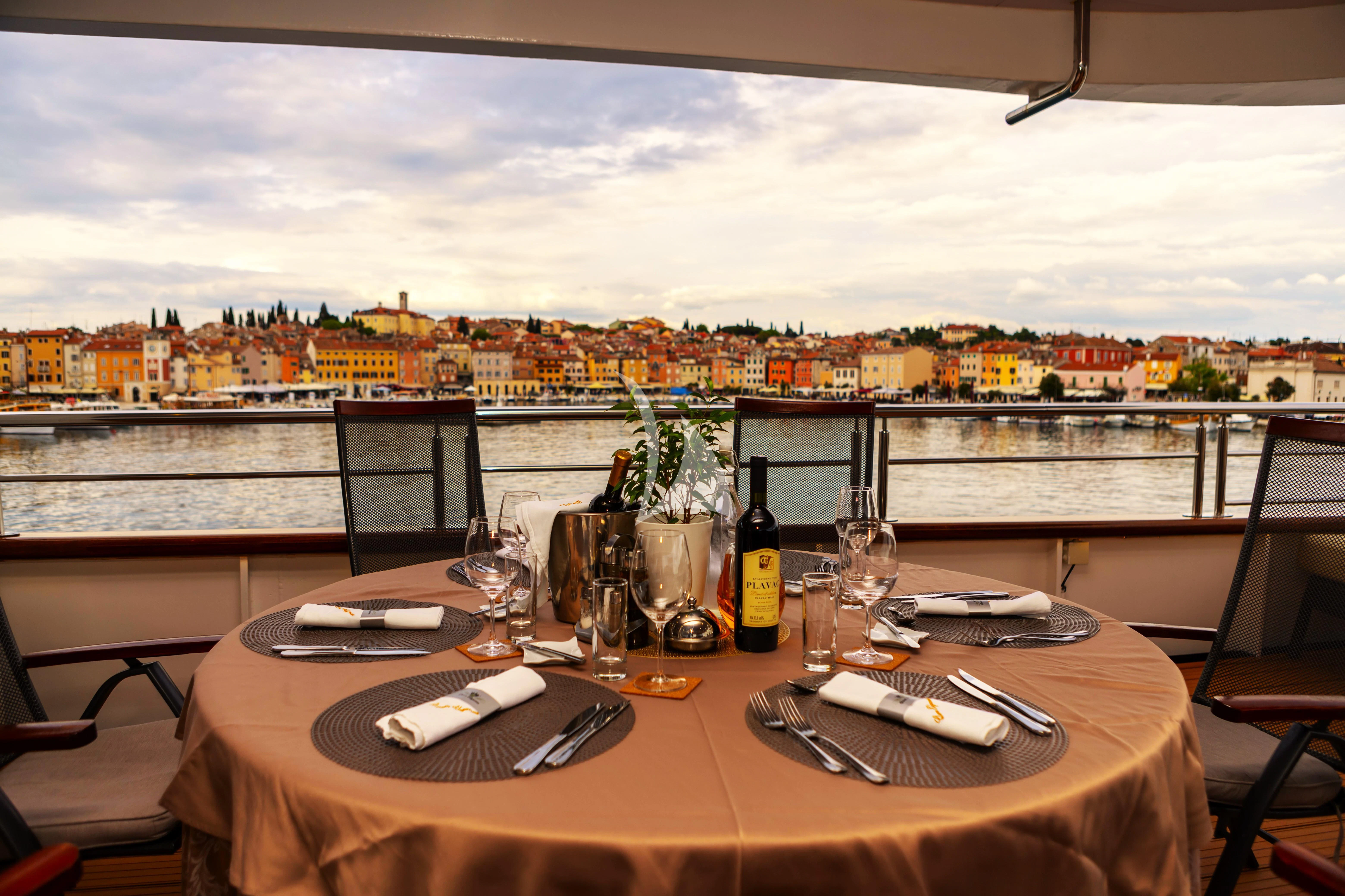 a table with plates and glasses on it aboard QUEEN ELEGANZA Yacht for Sale