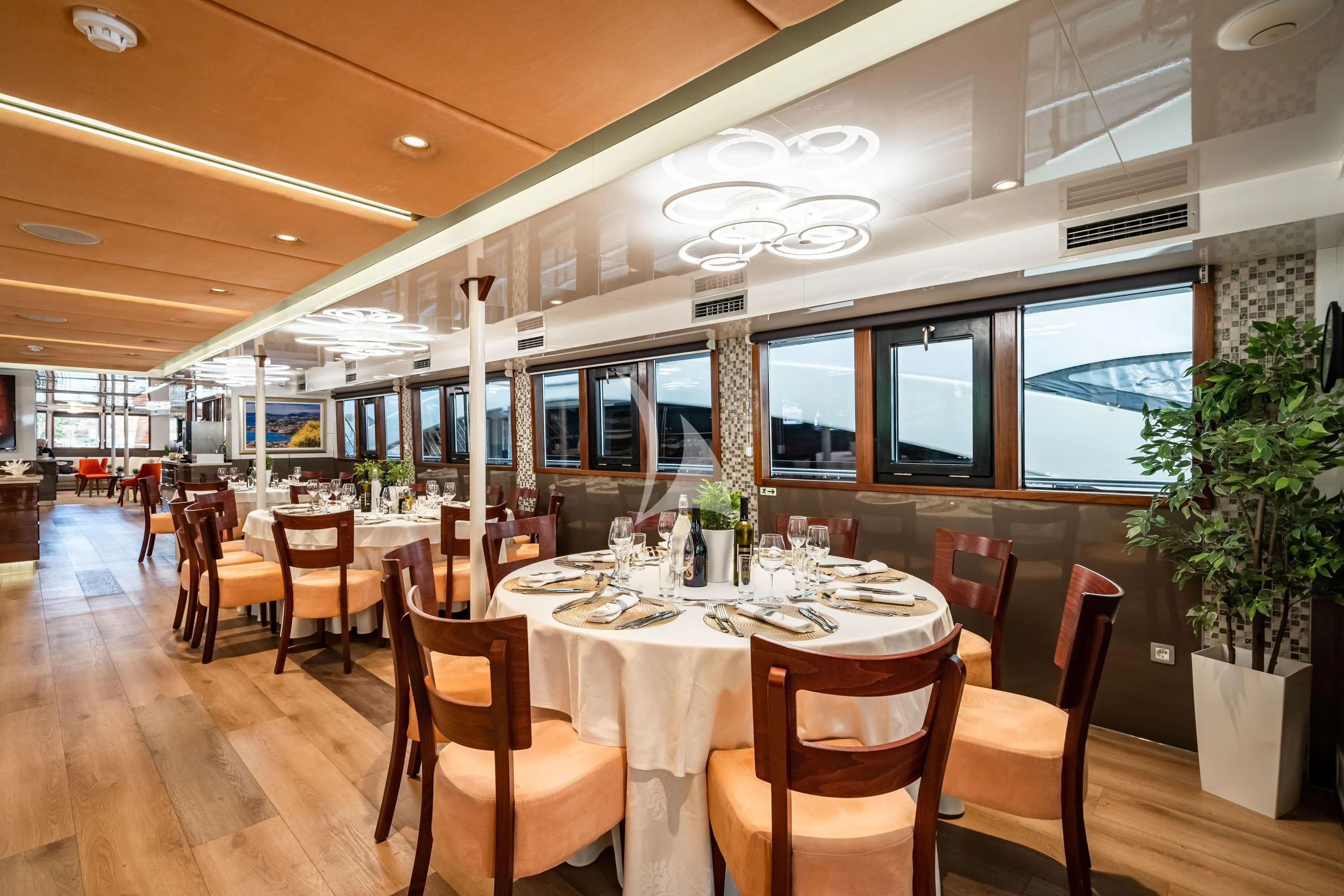 a restaurant with tables and chairs aboard QUEEN ELEGANZA Yacht for Sale