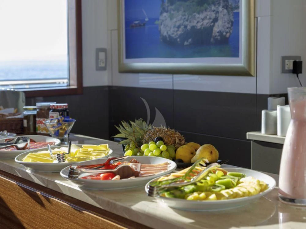 a table with plates of food aboard QUEEN ELEGANZA Yacht for Sale