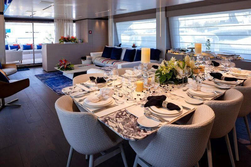a table set with plates and glasses aboard OFFICIAL PLAN Yacht for Sale