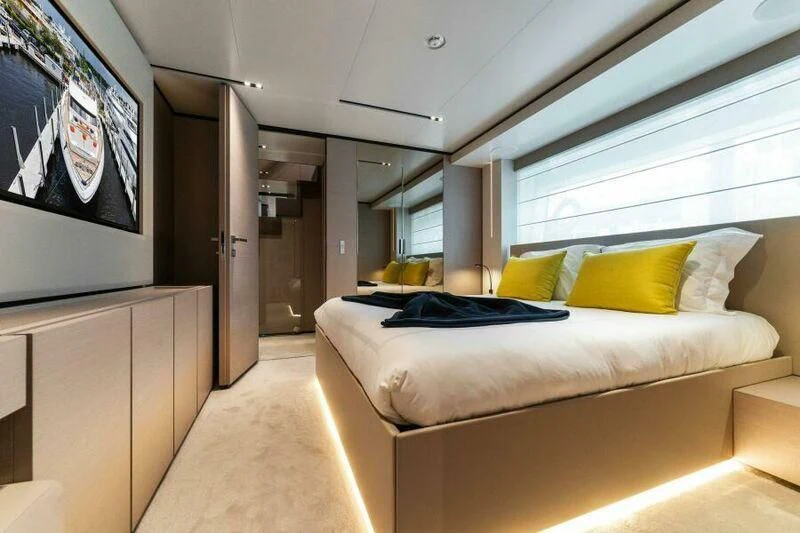 a room with a bed and a tv on the wall aboard OFFICIAL PLAN Yacht for Sale