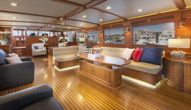 a living room with a large wood table and couches aboard VIRGINIA SEA Yacht for Sale