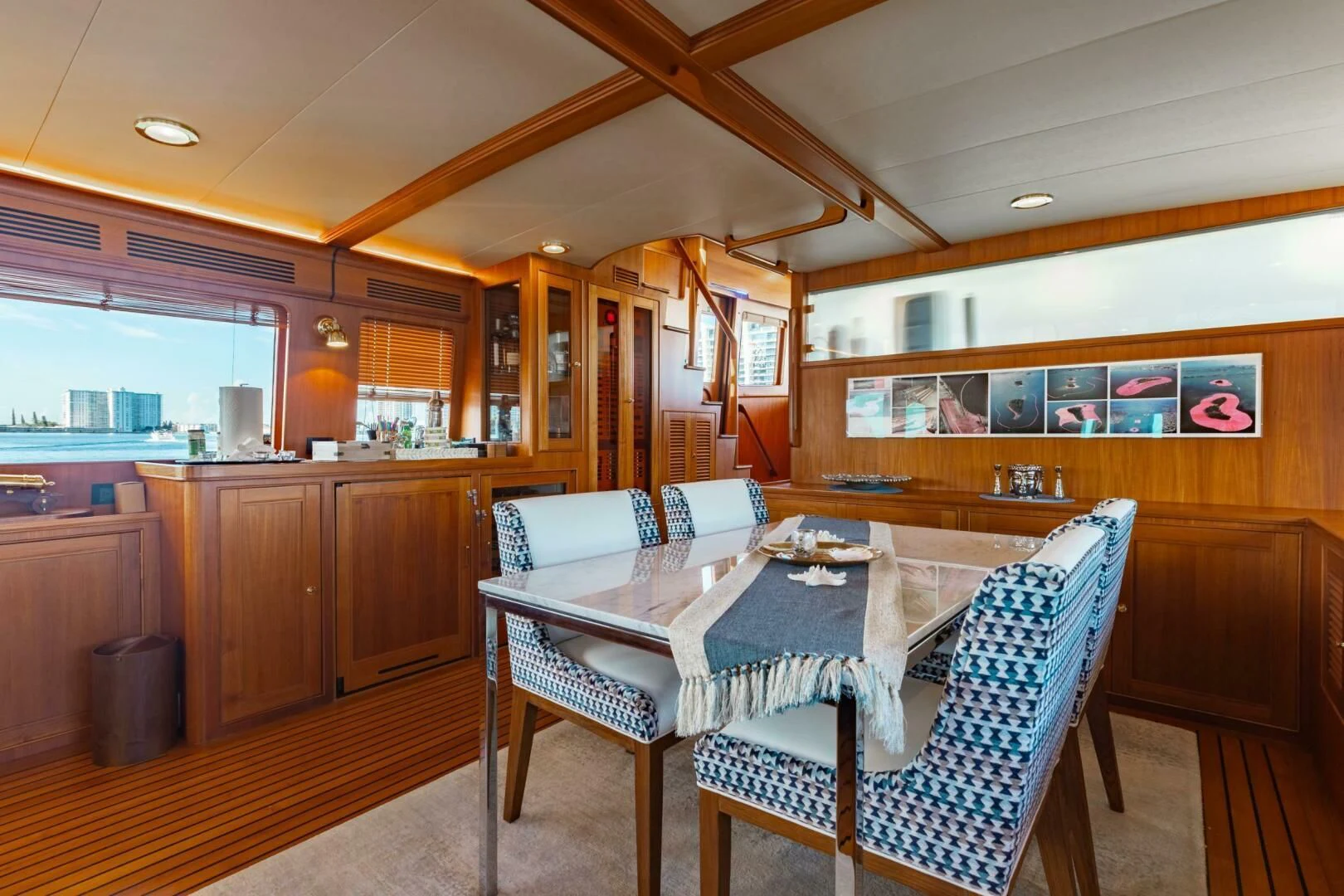 a dining table and chairs in a room with wood cabinets aboard VIRGINIA SEA Yacht for Sale