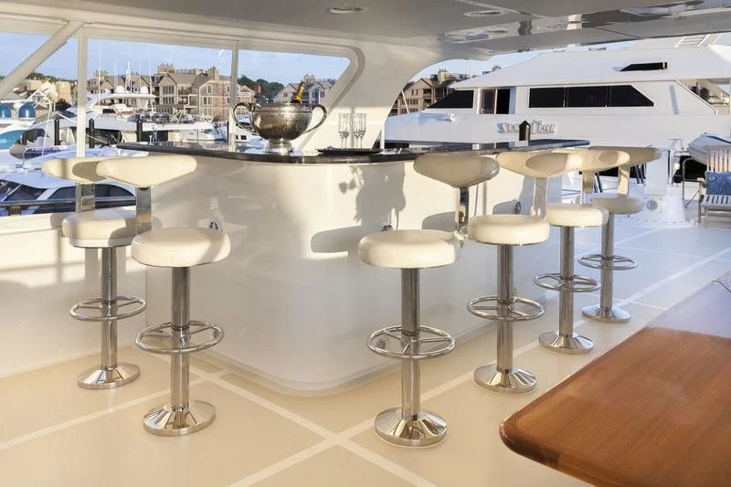 a group of stools in a room with a white boat in the background aboard VIRGINIA SEA Yacht for Sale