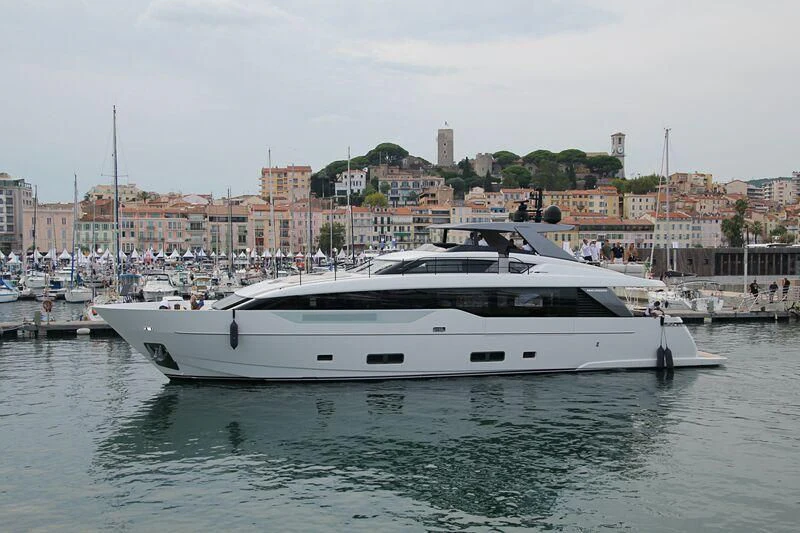 a white boat in a harbor aboard SEVEN Yacht for Sale