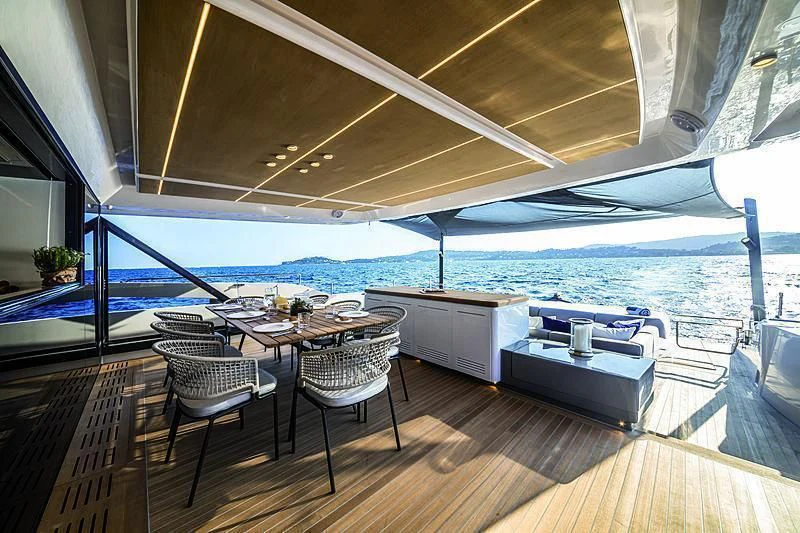 a deck with a table and chairs aboard SONEY Yacht for Sale