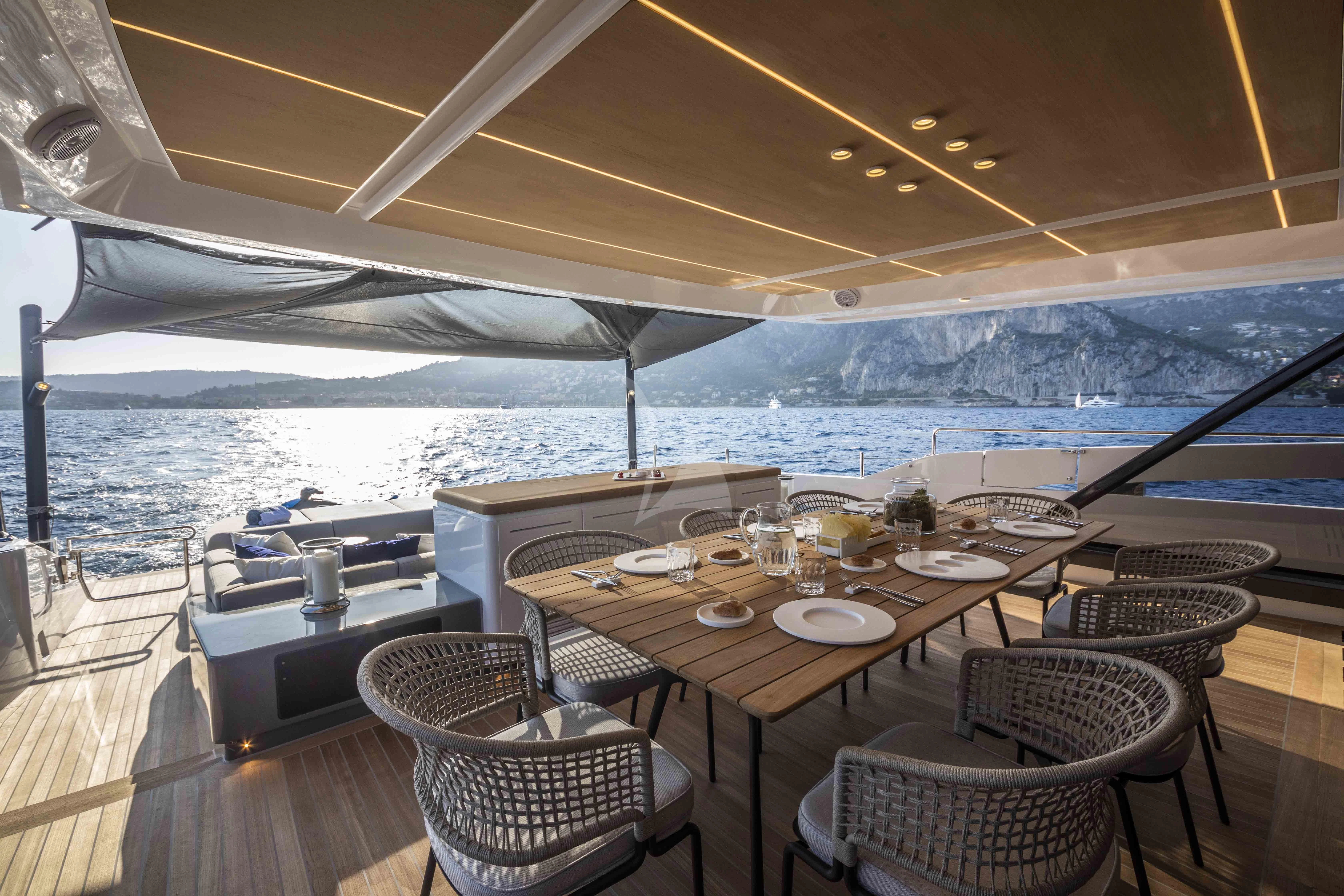 a table set for a meal on a deck overlooking a large body of water aboard SONEY Yacht for Sale