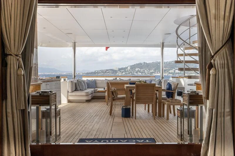 a room with a table chairs and a large body of water aboard TACANUYA Yacht for Charter