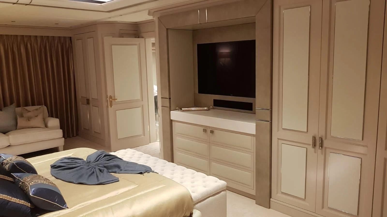 a bedroom with a bed and a tv aboard TACANUYA Yacht for Charter
