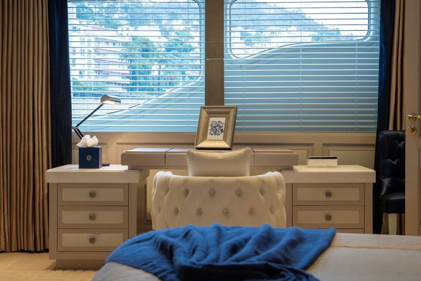 a bedroom with a bed and a window aboard TACANUYA Yacht for Charter