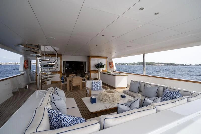a boat with a couch and a table and chairs aboard TACANUYA Yacht for Charter