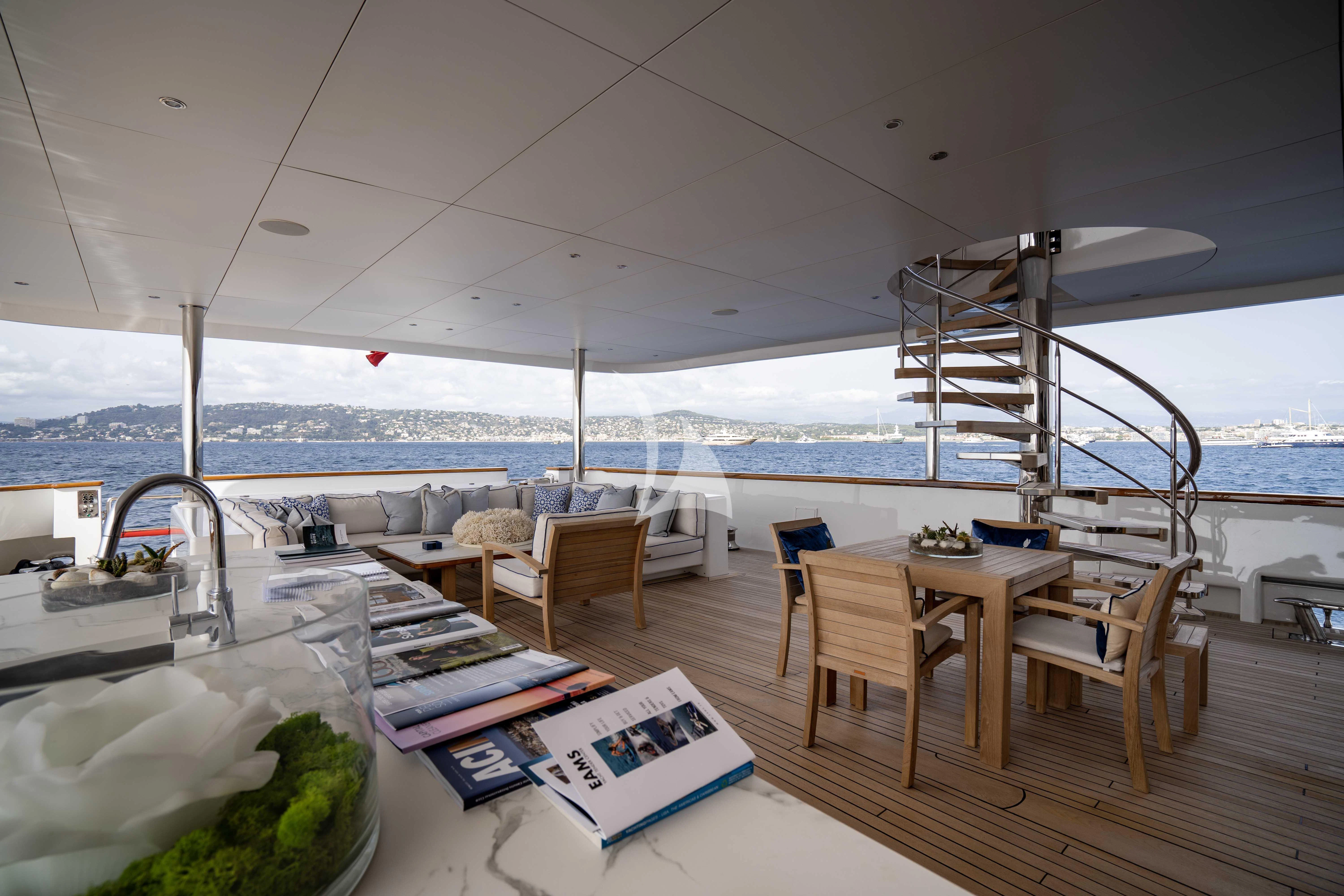a room with tables and chairs aboard TACANUYA Yacht for Charter