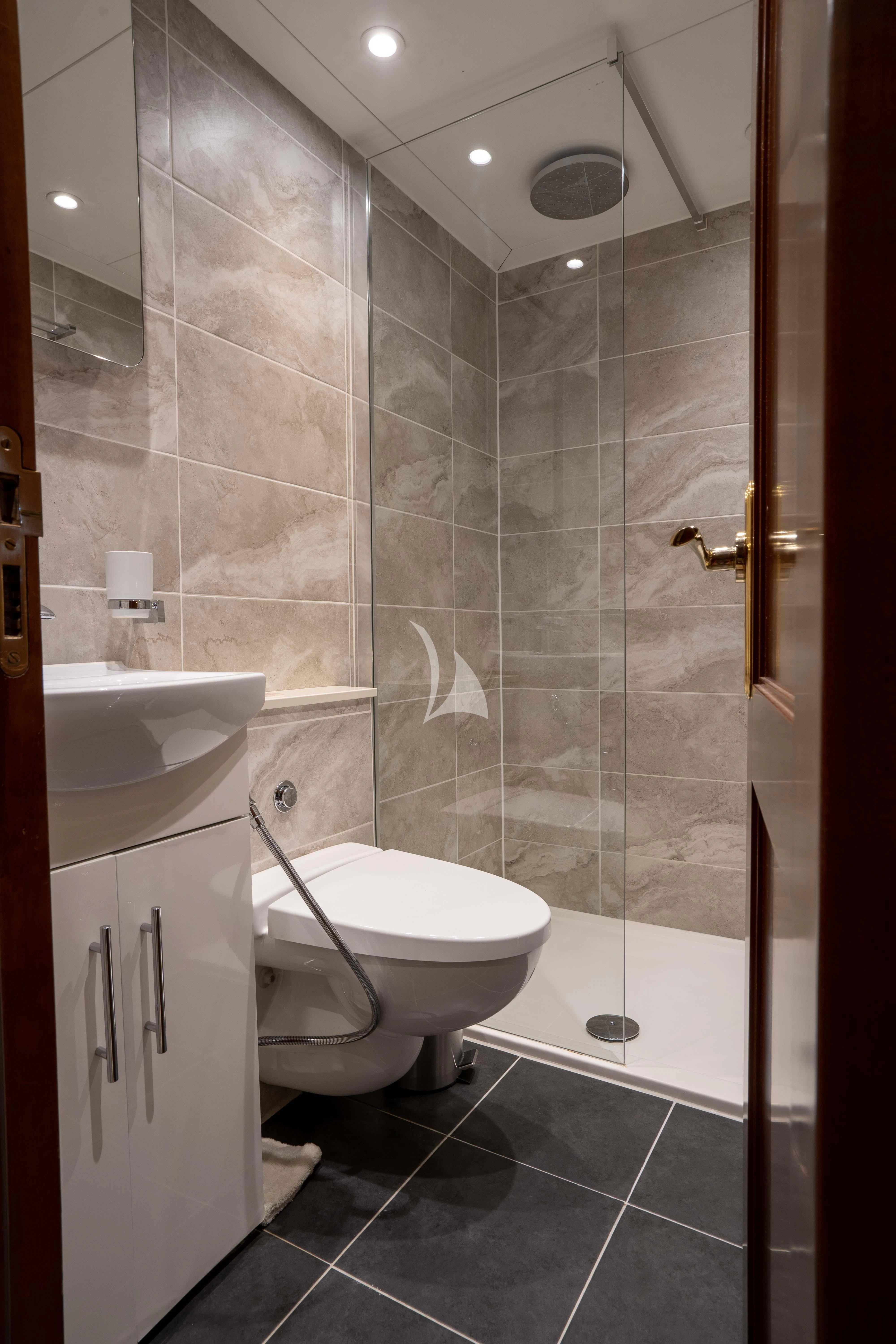 a bathroom with a glass shower aboard TACANUYA Yacht for Charter