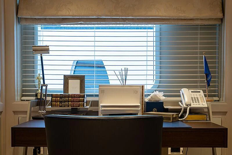 a desk with a computer and a lamp on it aboard TACANUYA Yacht for Charter