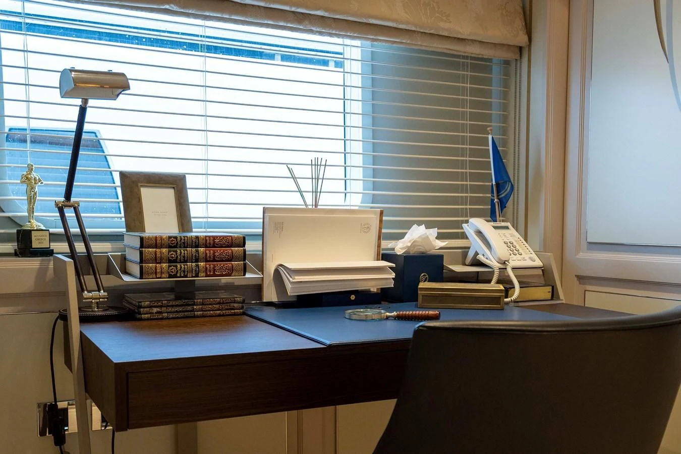 a desk with a computer and a lamp on it aboard TACANUYA Yacht for Charter