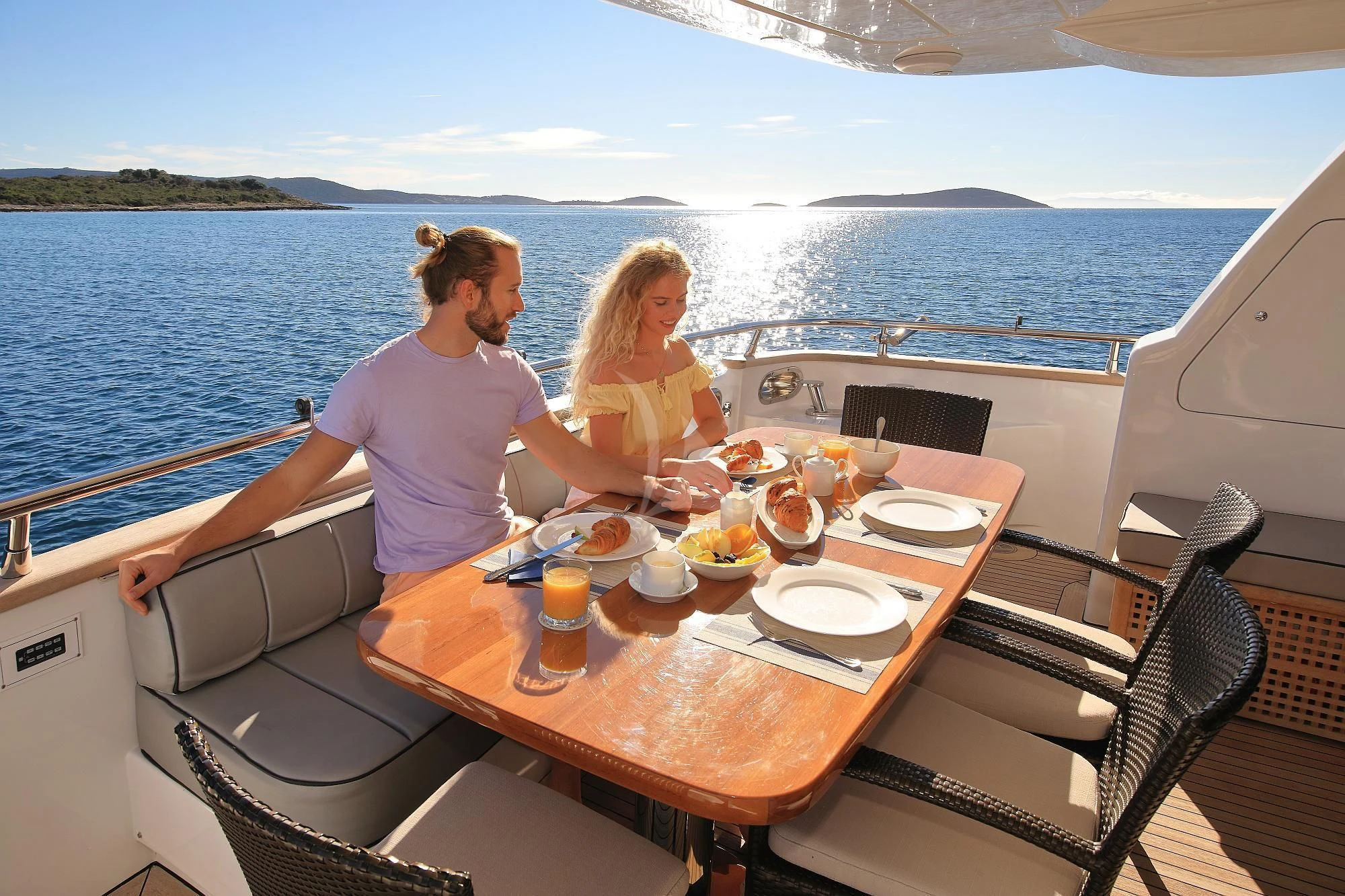 a man and woman sitting at a table with food on it aboard HOPE I Yacht for Charter