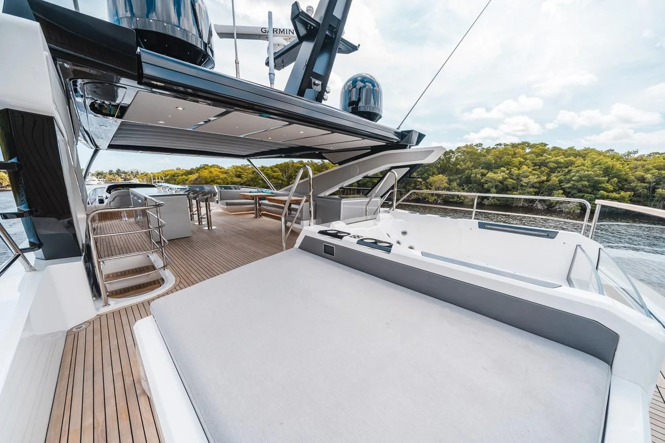 a deck with a large white boat on it and a white table with chairs and a white table aboard 90 OCEAN Yacht for Sale