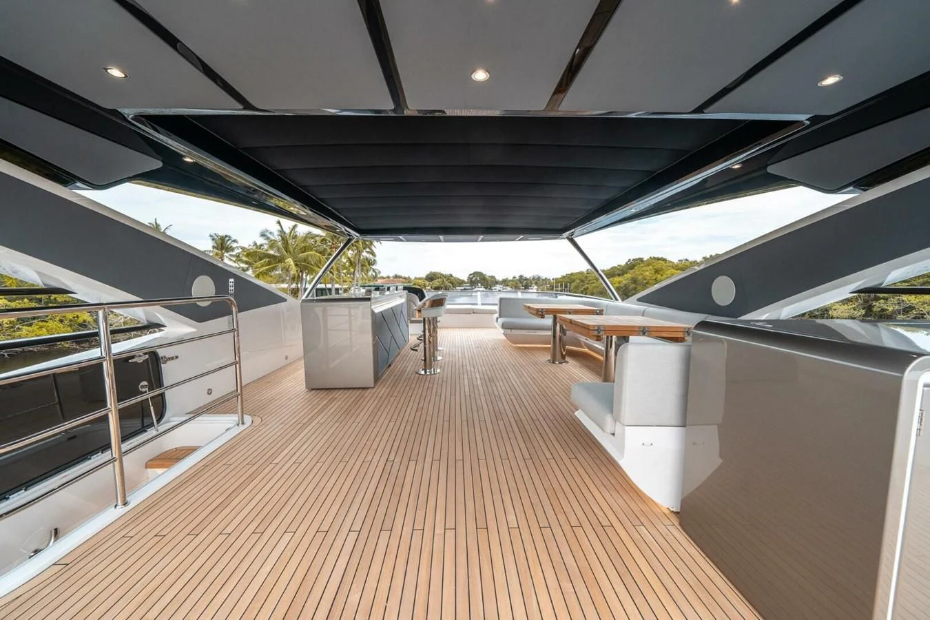 a long wooden deck with white furniture aboard 90 OCEAN Yacht for Sale