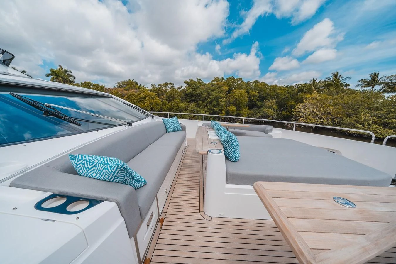 a white car parked on a wooden deck with a blue umbrella on it aboard 90 OCEAN Yacht for Sale