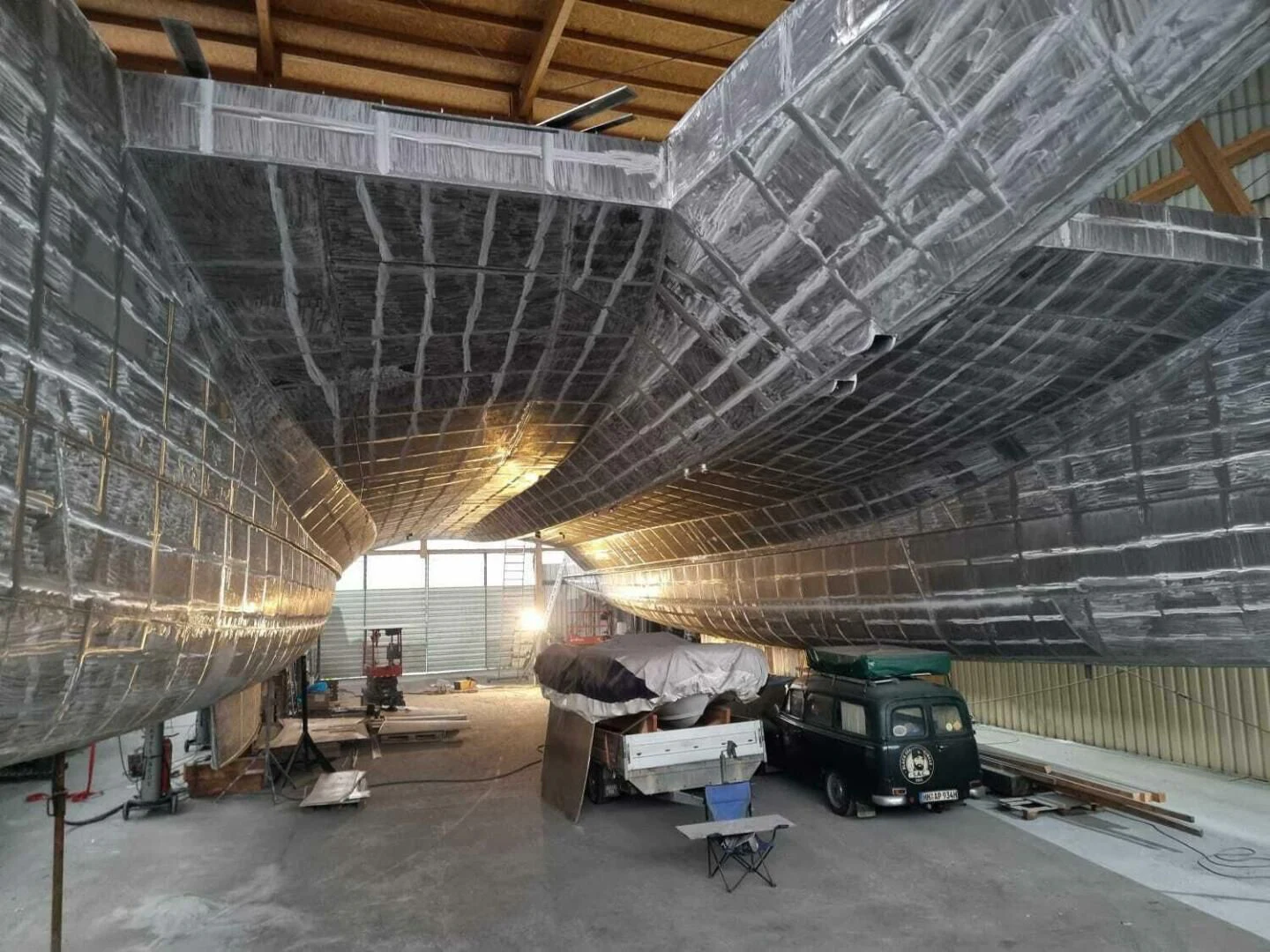 a person sleeping on a couch in a large room with a large ceiling aboard CUSTOM 107 CATAMARAN Yacht for Sale