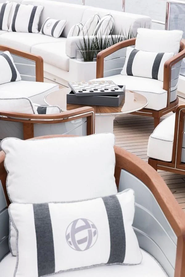 a white couch with a black and white striped pillow in a living room aboard GAJA Yacht for Sale