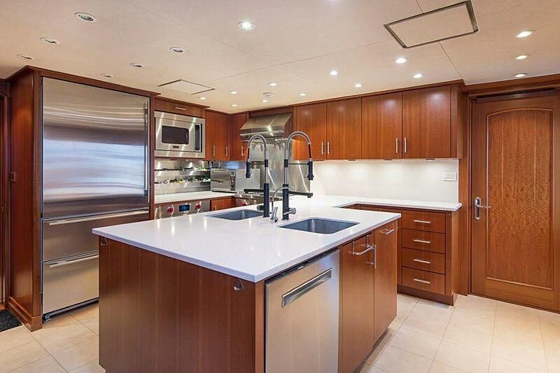 a kitchen with wooden cabinets aboard MAMAMIA Yacht for Sale