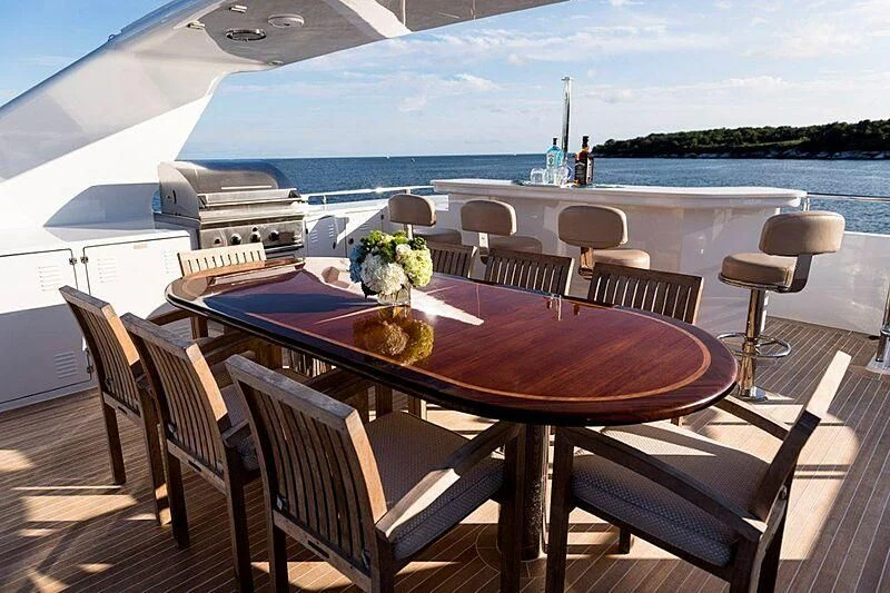 a table set for a meal on a balcony overlooking the ocean aboard MAMAMIA Yacht for Sale