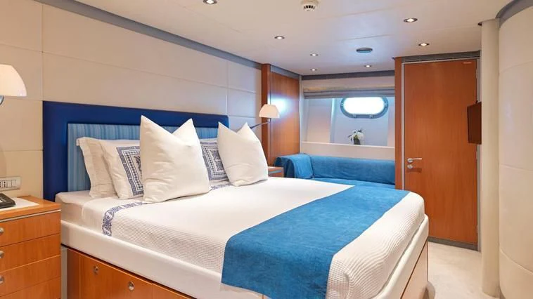 a bed with blue sheets aboard ALMA Yacht for Sale