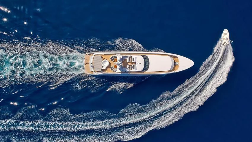 a bottle of beer on a beach aboard ALMA Yacht for Sale