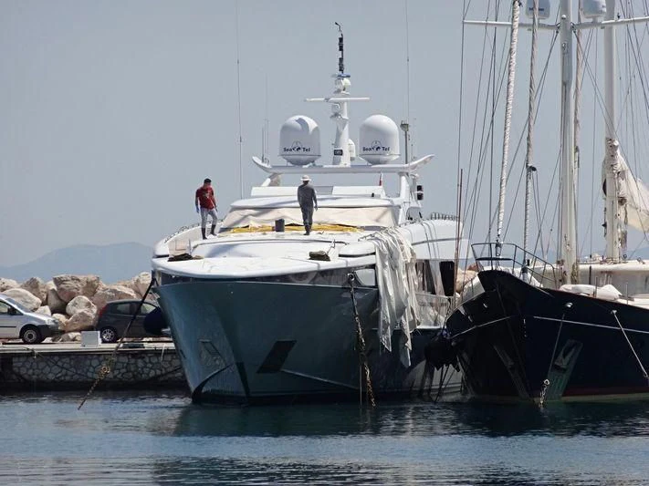 a large white boat with two men on it aboard ALMA Yacht for Sale