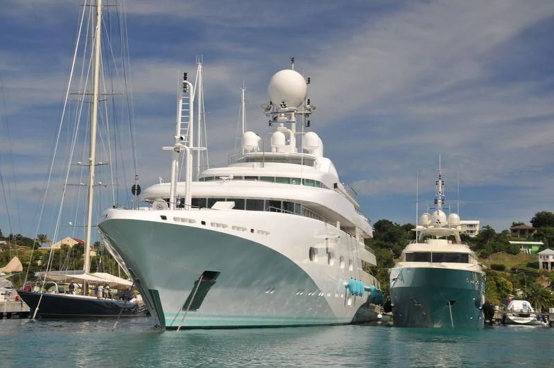 a large white boat next to a smaller boat in the water aboard PEGASUS VIII Yacht for Sale