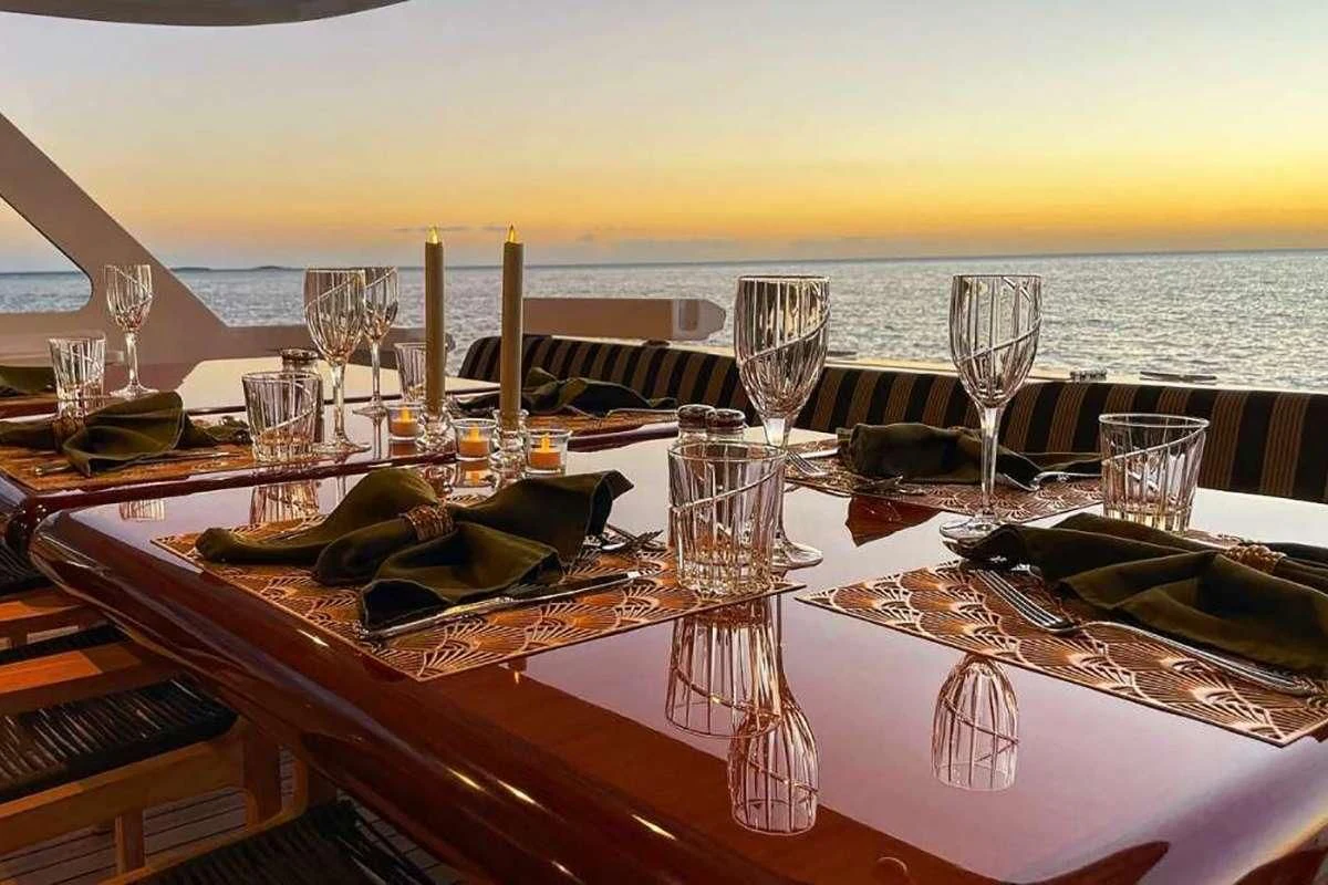 a table with wine glasses and plates on it aboard LONE STAR Yacht for Sale