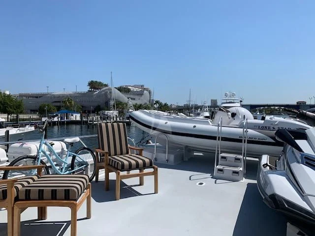 a deck with chairs and tables aboard LONE STAR Yacht for Sale
