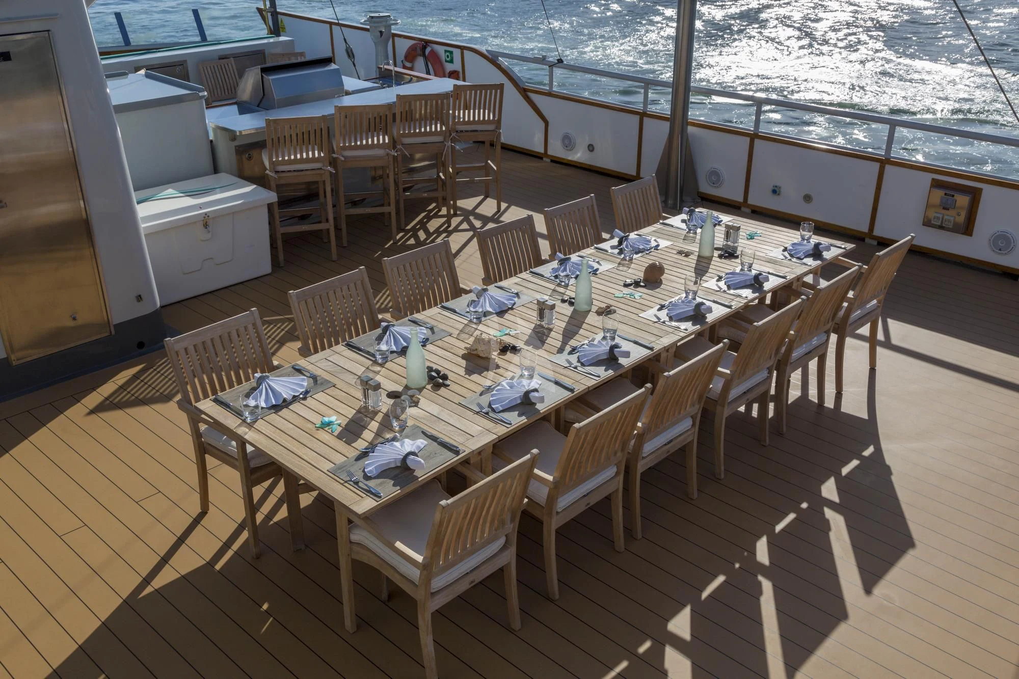 a table set for a meal on a deck aboard HYDRA Yacht for Sale