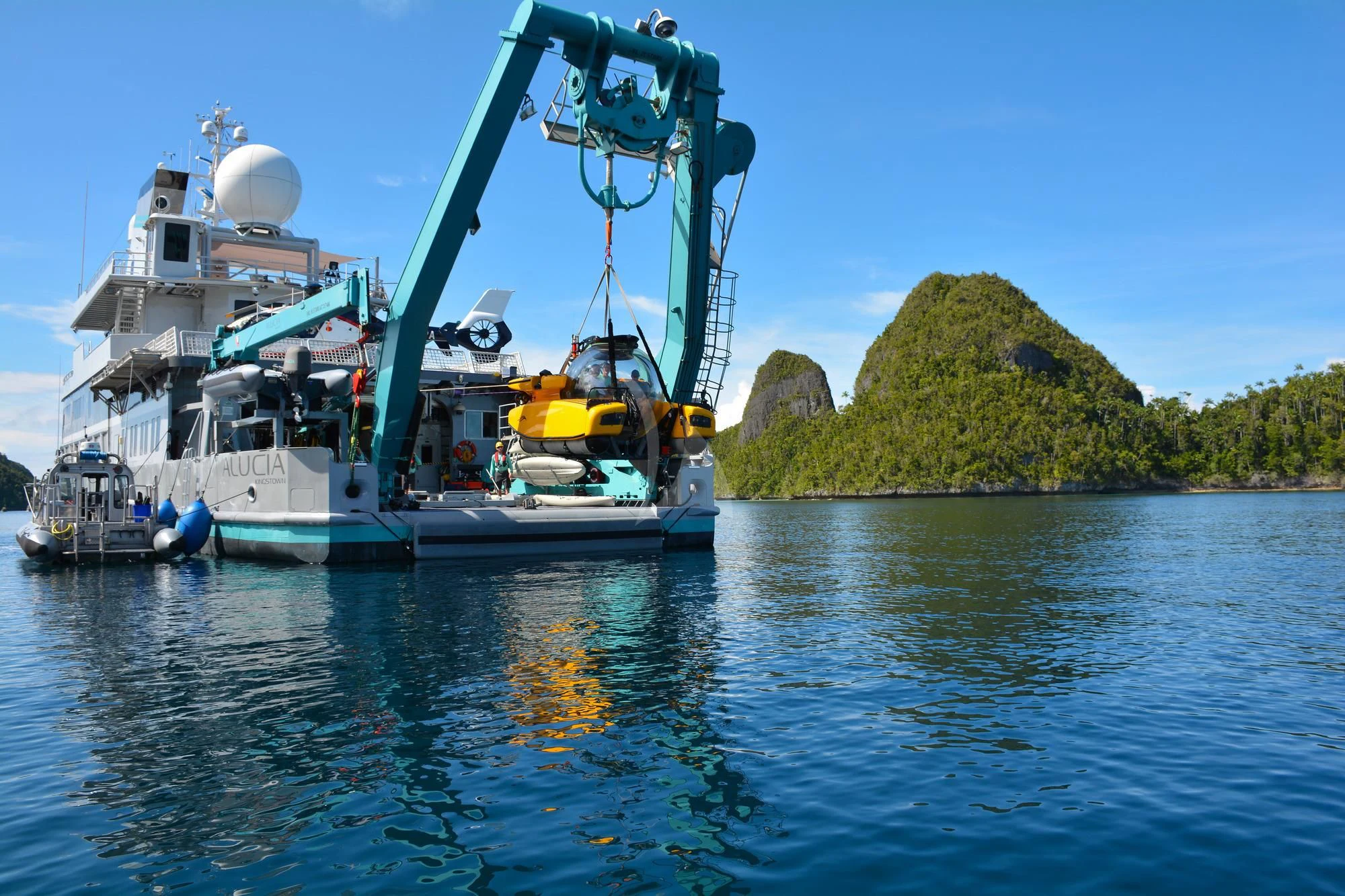 a large crane lifting a boat aboard HYDRA Yacht for Sale
