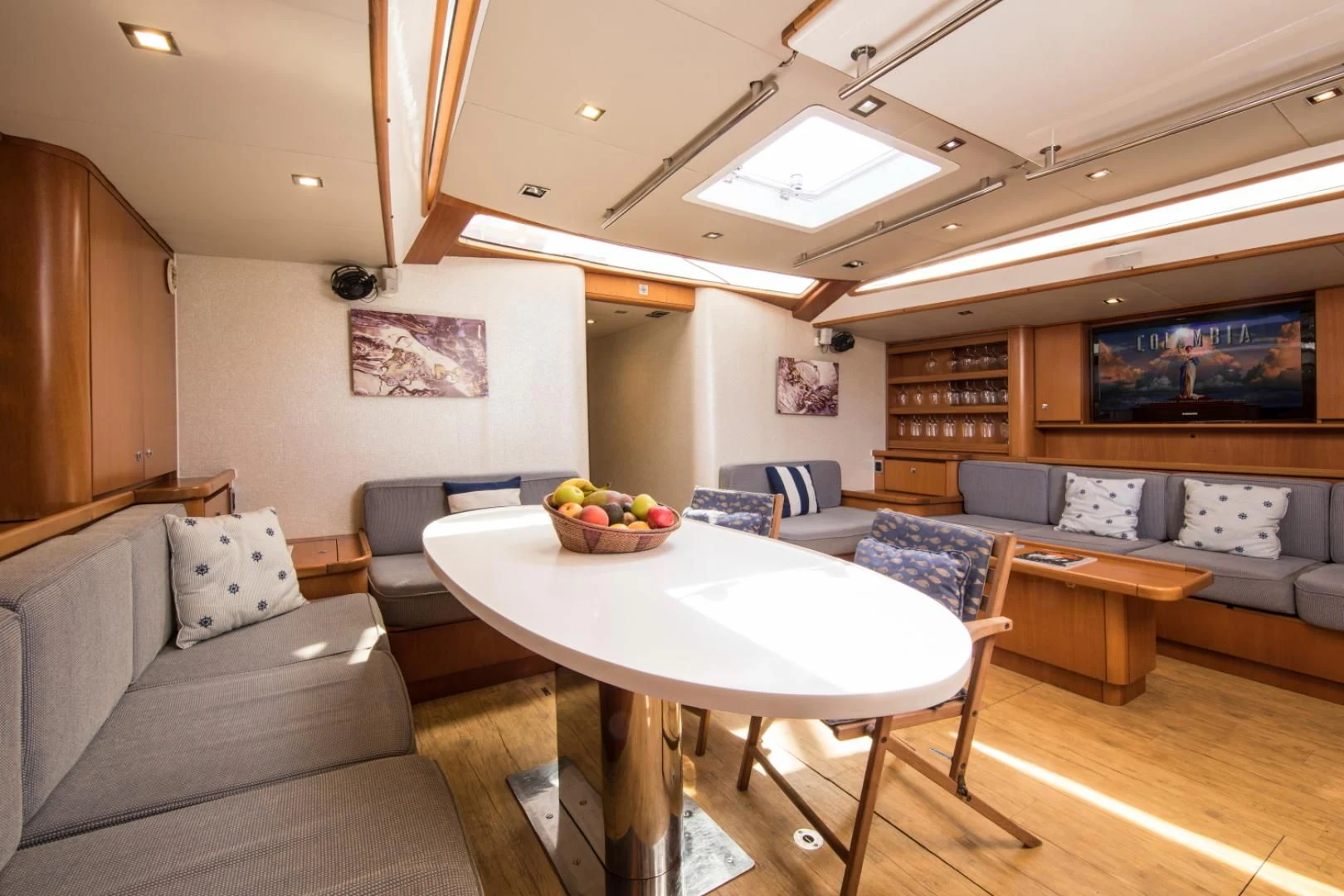 a living room with a table and couches aboard INDIGO Yacht for Sale