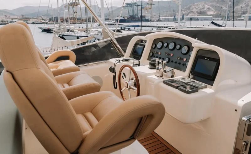 a hand holding a steering wheel of a boat aboard APOLLO I Yacht for Sale