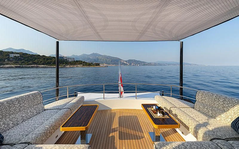 a deck with a view of the ocean and mountains in the background aboard A2 Yacht for Sale