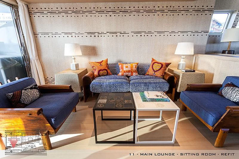 a living room with a blue couch and a coffee table aboard A2 Yacht for Sale