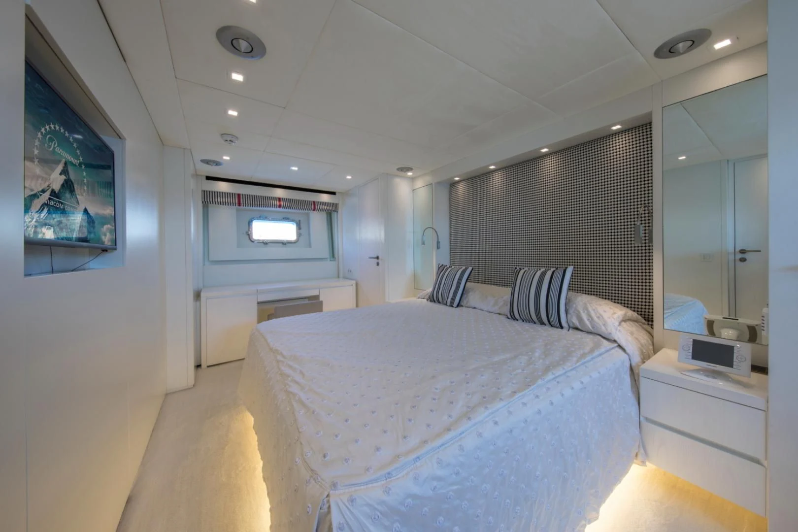 a bedroom with a bed and a tv on the wall aboard MAI Yacht for Sale