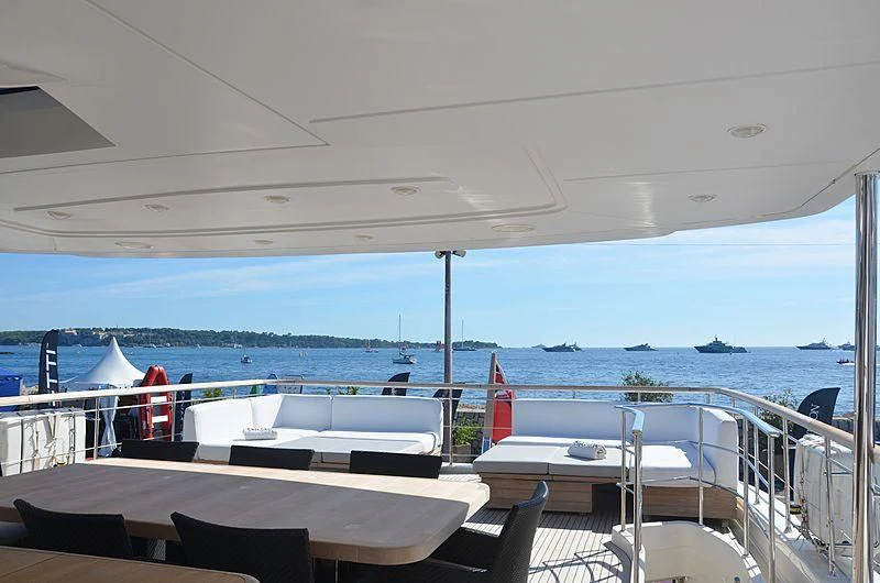 a deck with chairs and tables on it aboard MAI Yacht for Sale