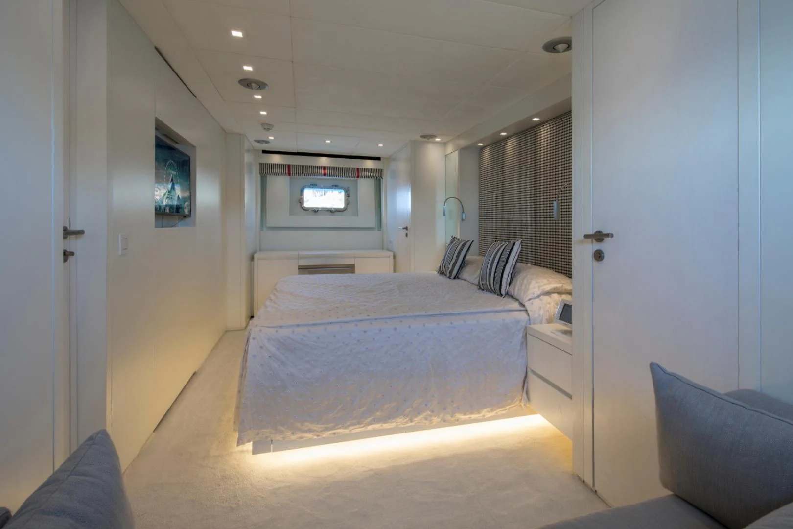 a bedroom with a bed and a chair aboard MAI Yacht for Sale
