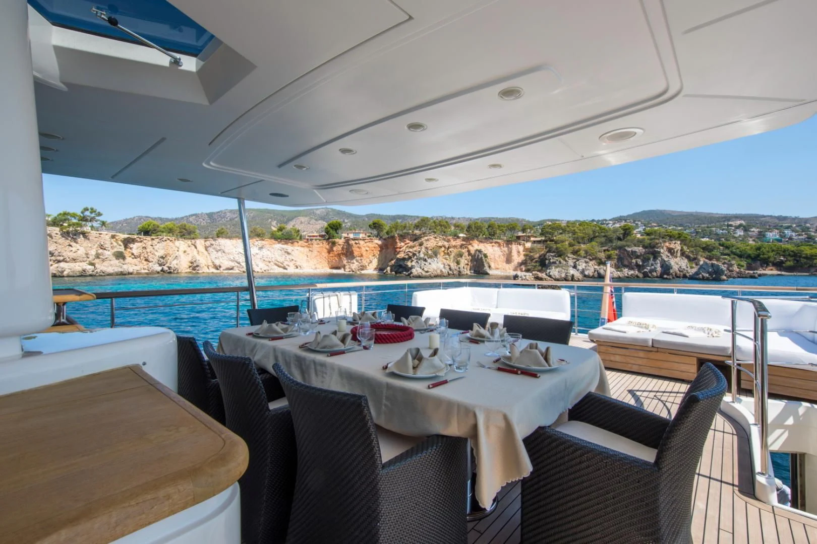a table set for a meal on a deck overlooking a large body of water aboard MAI Yacht for Sale