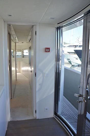 a hallway with glass doors aboard MAI Yacht for Sale