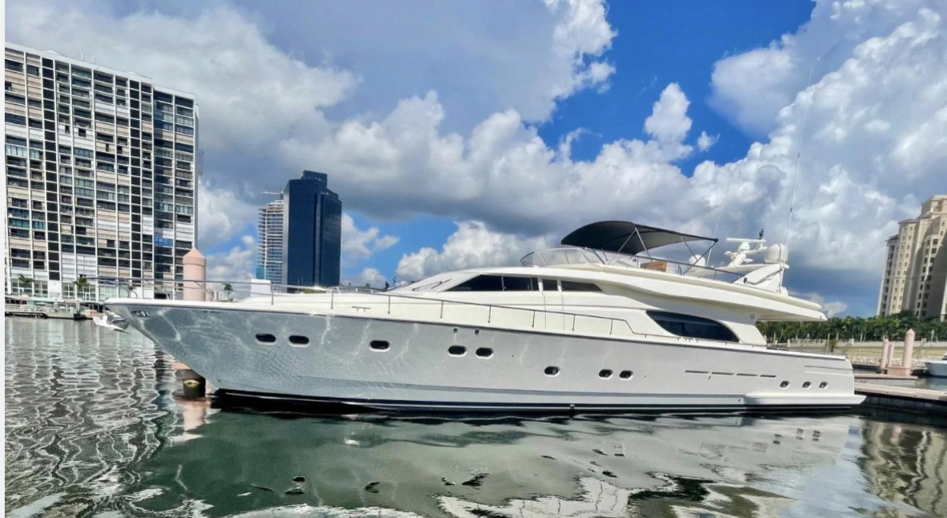 a white yacht in a body of water with buildings in the background aboard RABBIT Yacht for Sale