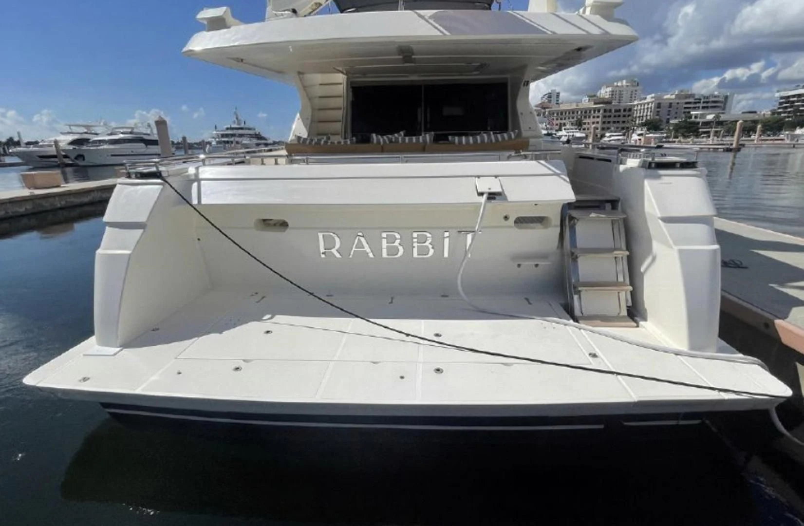 a white yacht in a harbor aboard RABBIT Yacht for Sale