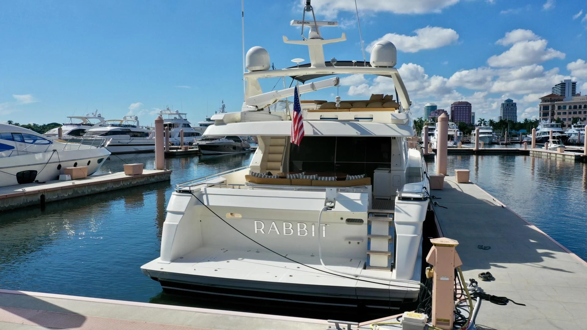 a large white boat docked at a pier aboard RABBIT Yacht for Sale